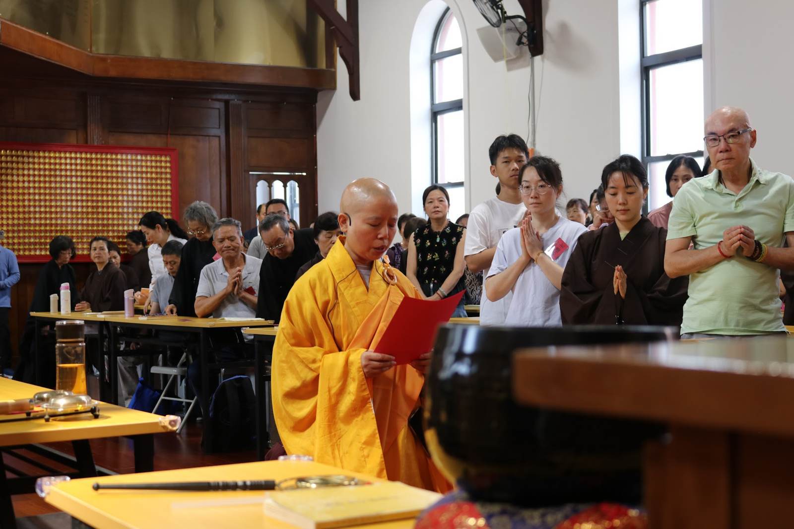 A monastic leading devotees in recitation
